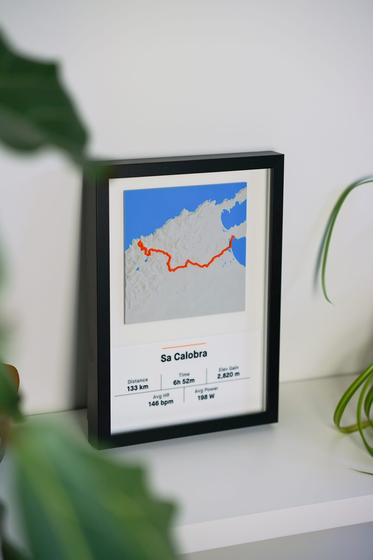 Framed Sa Calobra minimal relief piece styled on a white shelf with more room context.