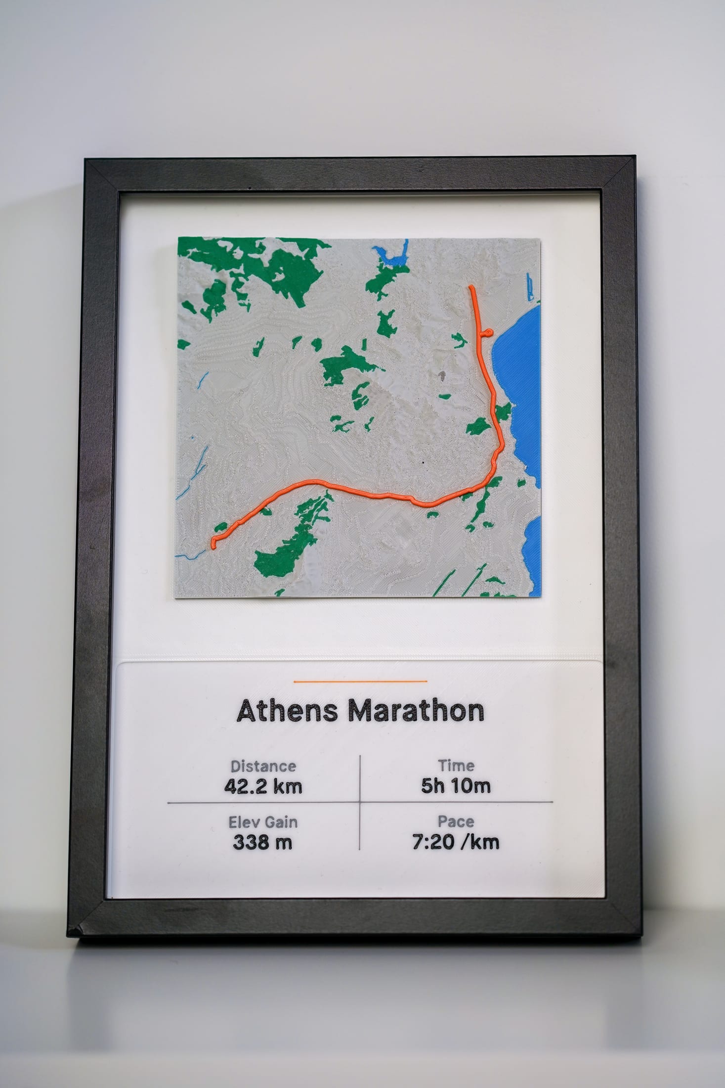 Straight-on photograph of the framed Athens Marathon terrain piece.
