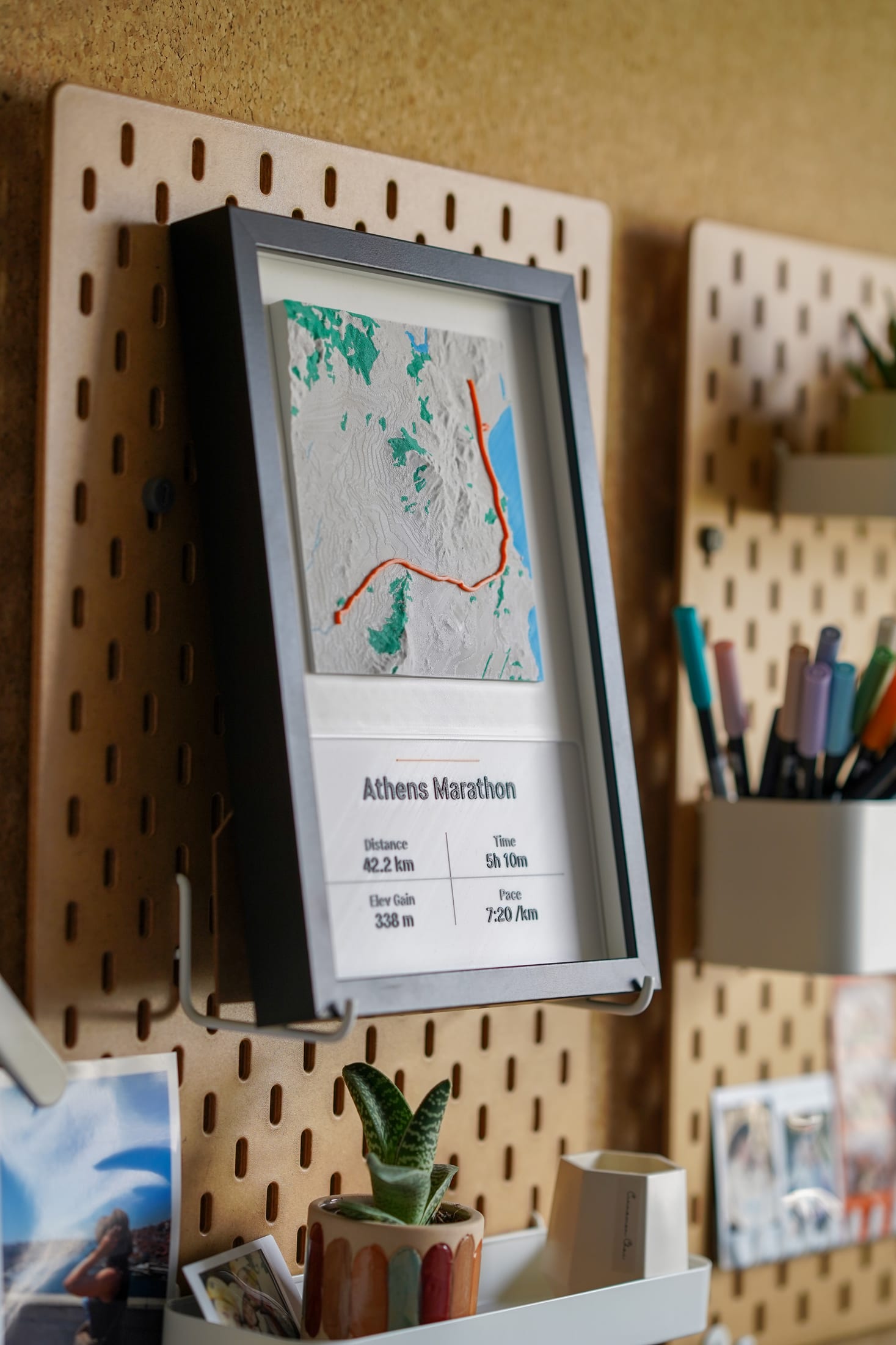 Angled photograph of the Athens Marathon piece mounted on a pegboard workspace.